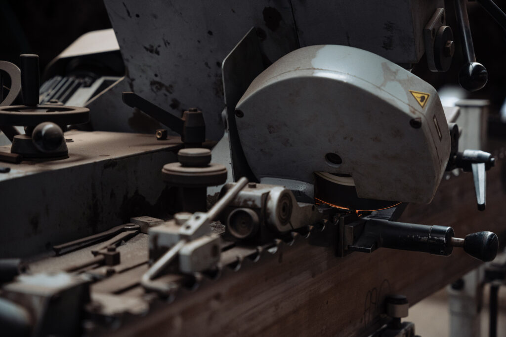 Grosse machine industrielle de sciage de bois en action dans un atelier.