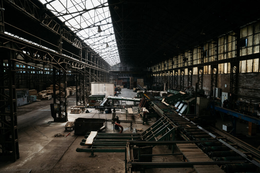 Pièce de bois en cours de sciage par une machine industrielle dans un atelier.